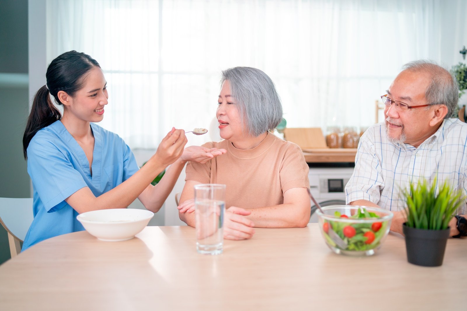 nurse-or-doctor-who-work-as-homecare-staff-help-to-serve-a-spoon-of-mush-rice-to-senior-woman.jpg